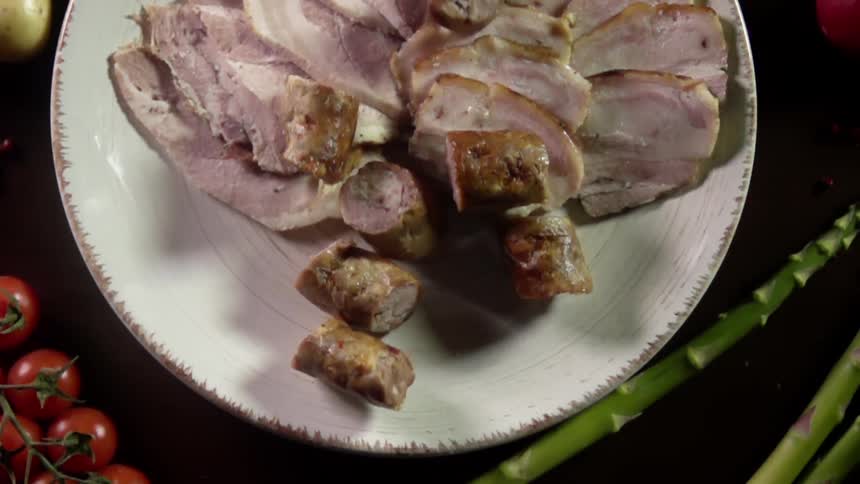 Pieces of sausage are thrown onto the plate