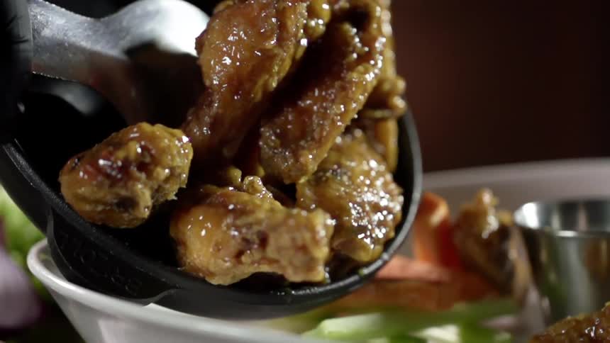 Chicken wings being put on to a platter