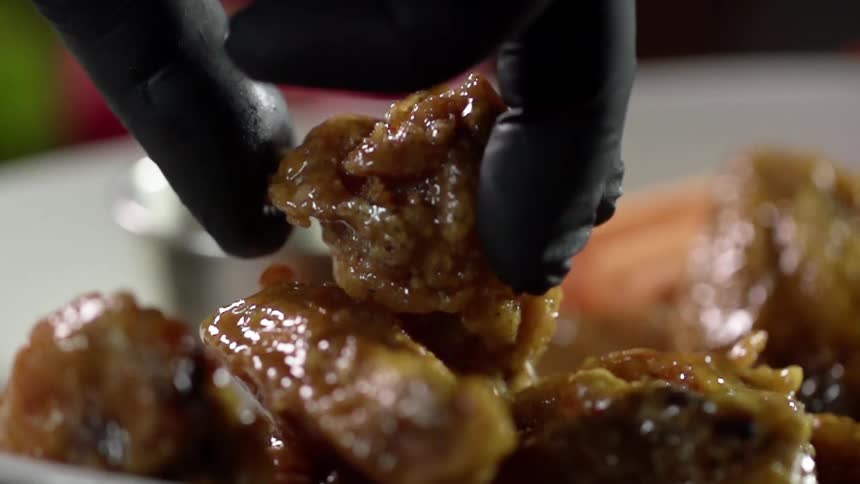 A person picking a piece of food off a plate