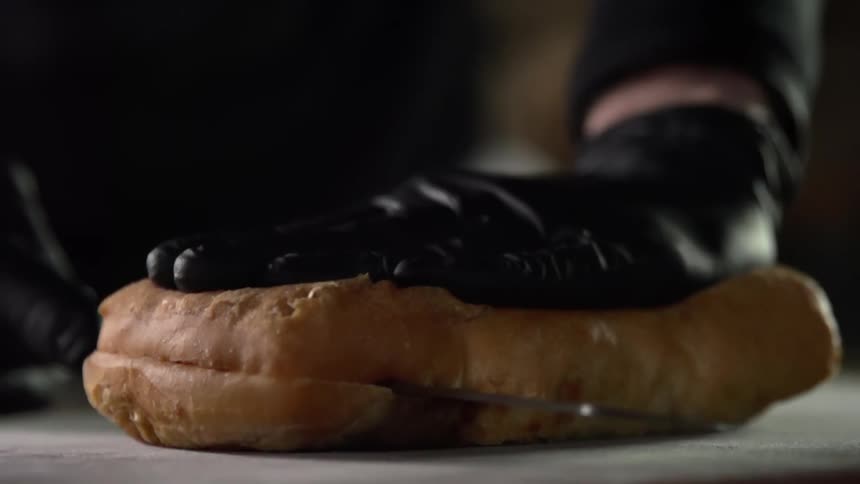 A person cuts bread in half