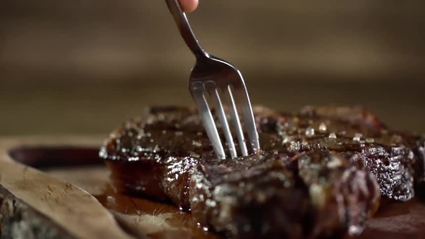 A person puts their fork in the steak
