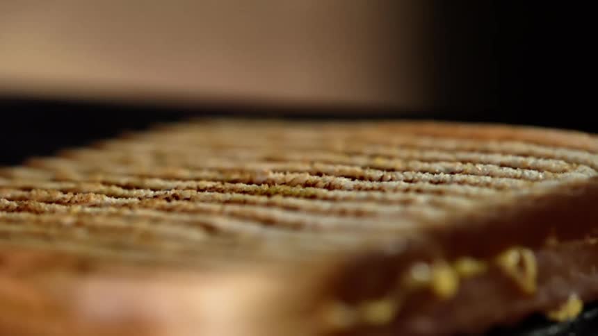 A sandwich has lines on the surface on the bread indicating that it was grilled