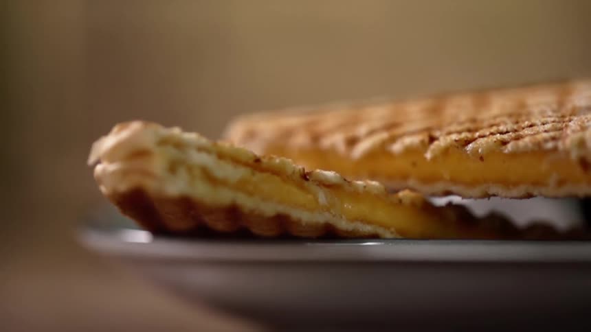 Close up of a toasted sandwich being put on a plate
