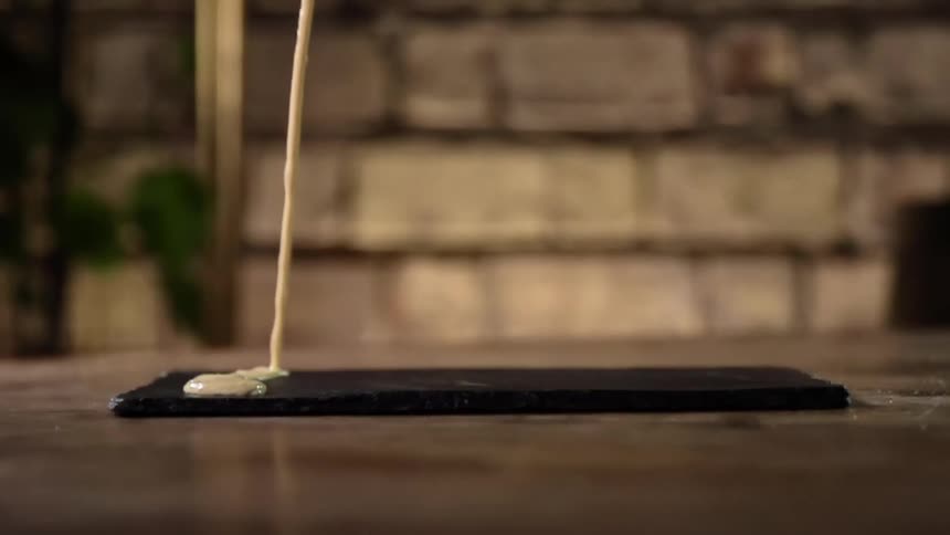 Sauce pours onto a wooden platter