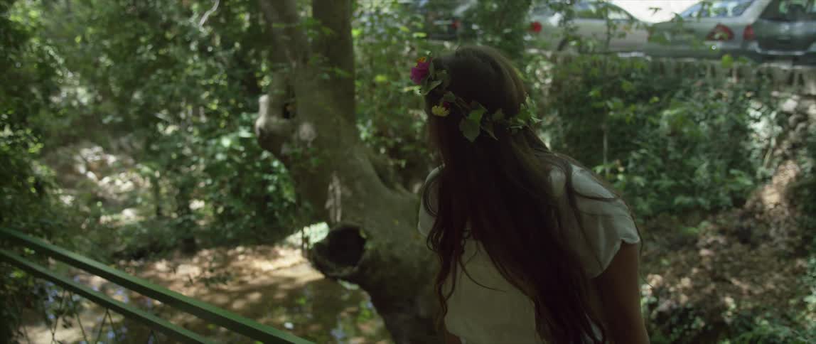 Smiling woman wearing headband made of flowers and leaves