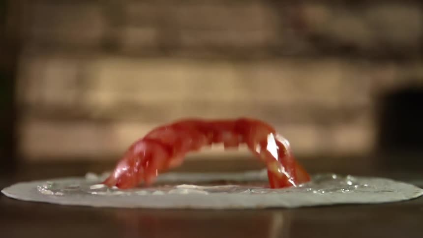 Tomato slices are dropped on the tortilla