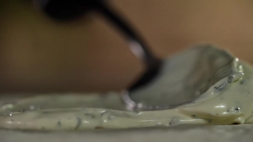 A spoon spreading cream on a surface