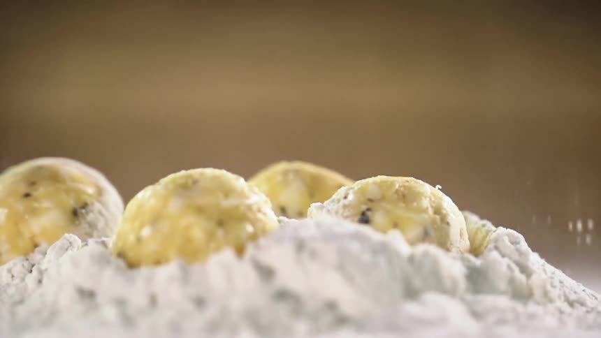 Vegetarian meatballs fall over a pile of flour in a table