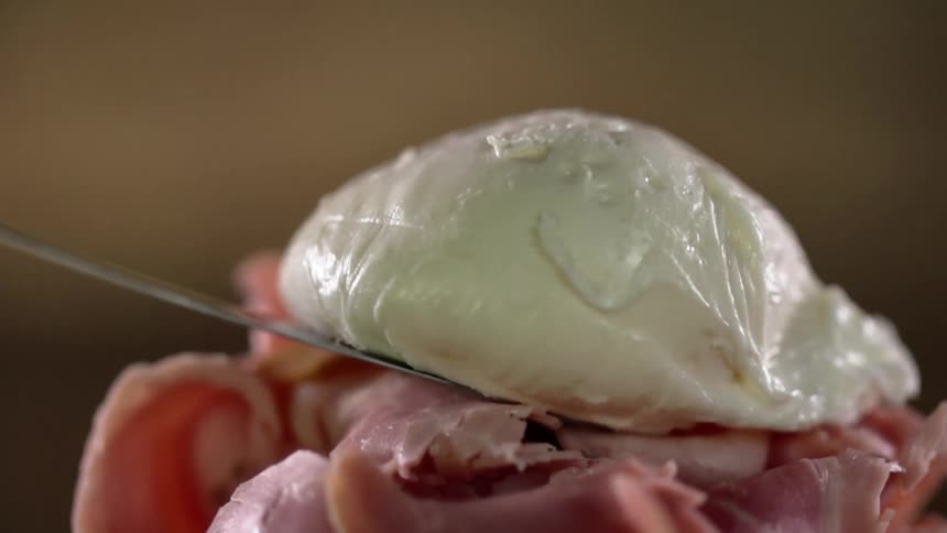 A poached egg is placed on a pile of meat
