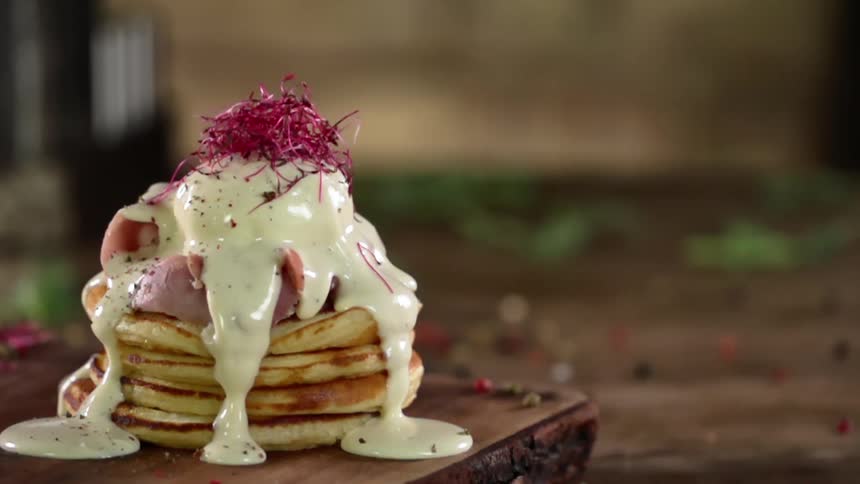 A stack of pancakes with sauce and spices on it