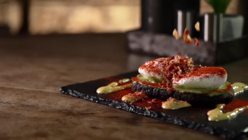 Garnishes are put on top of plated food at a restaurant