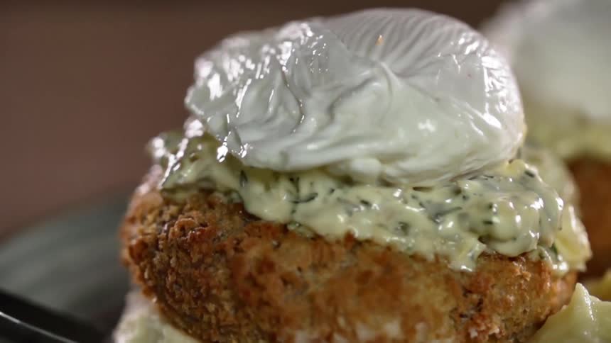 Fried nugget over a piece of bread covered with creams placed on a plate