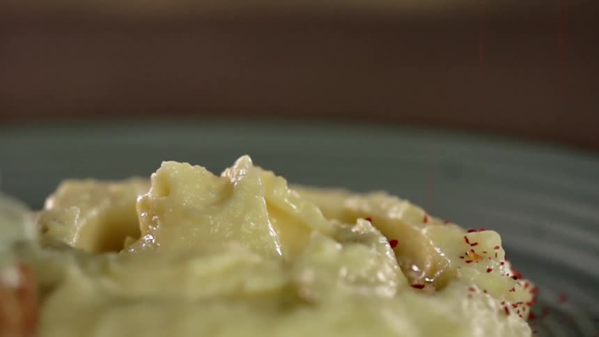 Mashed potatoes seasoned with red grains of spice over a plate