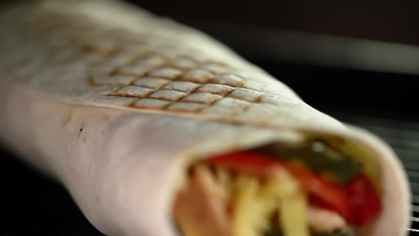 Flour tortilla burrito grilling in an electric grill