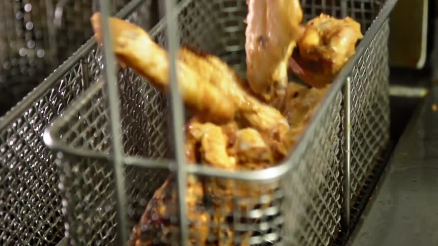 Meat falls into a metal frying bin