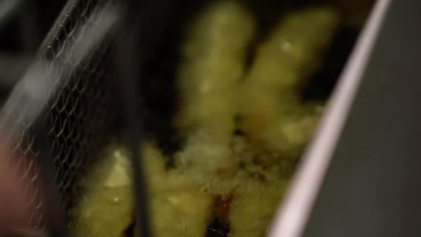 Breaded shrimp cook in a deep fat fryer