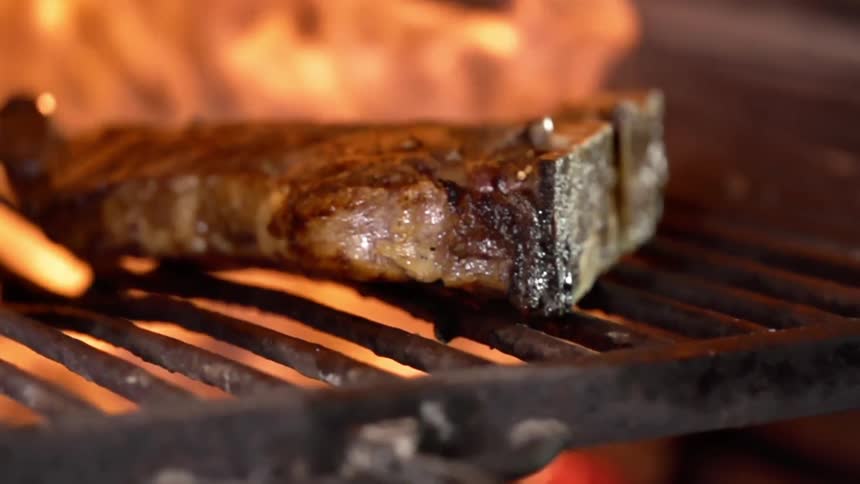 Tbone steak cooking over the fire in a grill
