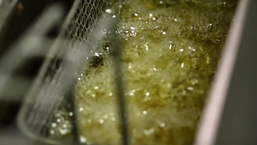 Food bubbles away in a deep fat fryer basket