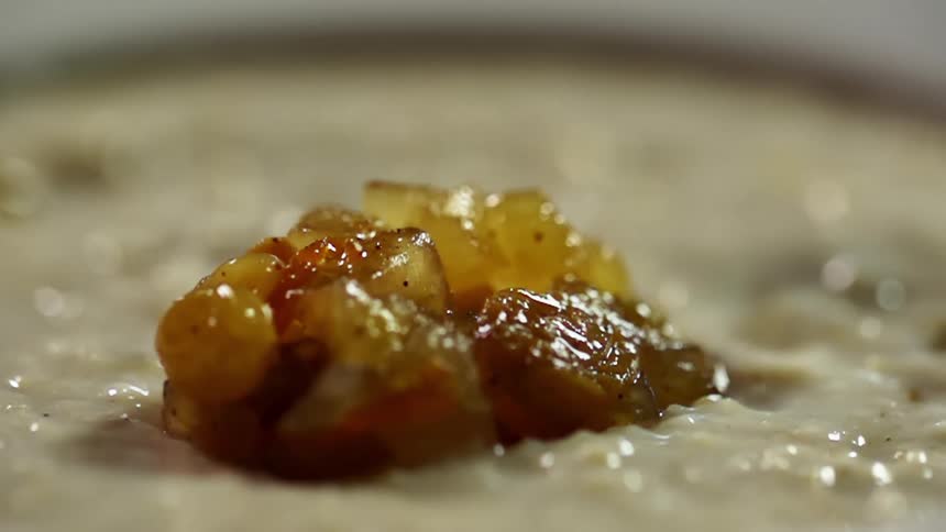 A bowl of oatmeal with diced cinnamon apples on top