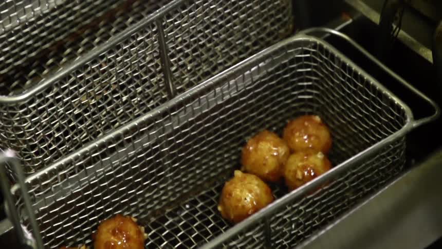 A basket of food being lifted out of a deep fryer