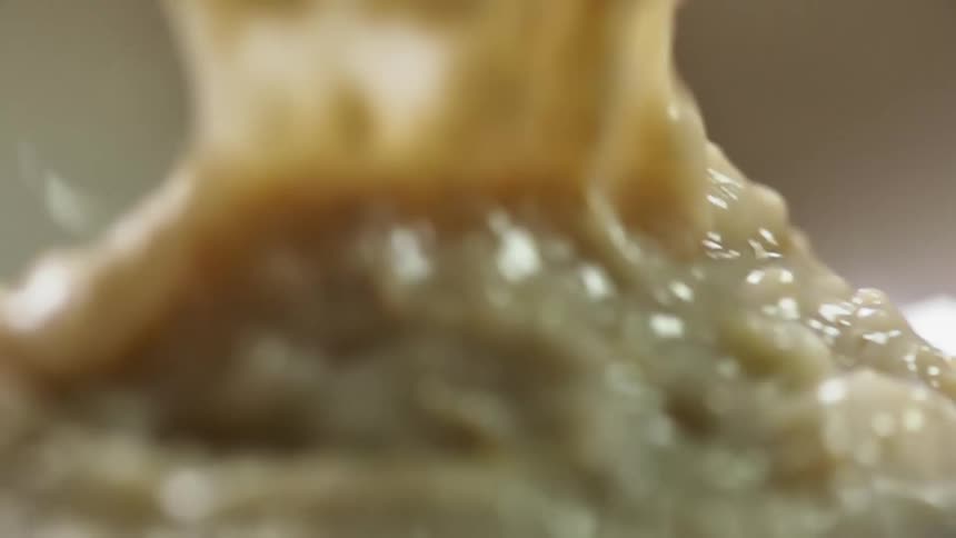 A pile of diced raw fish have a thick creamy sauce poured over it
