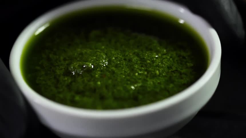 A person sets a bowl of sauce down