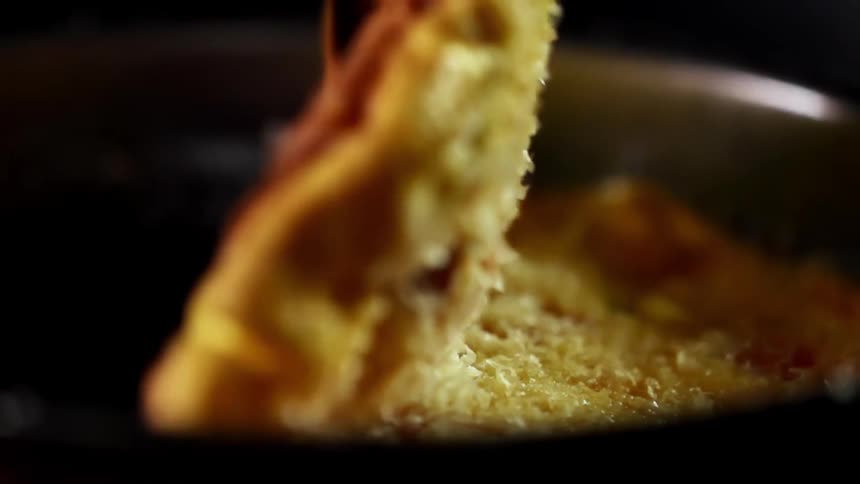An omelet cooking a pan gets folded over