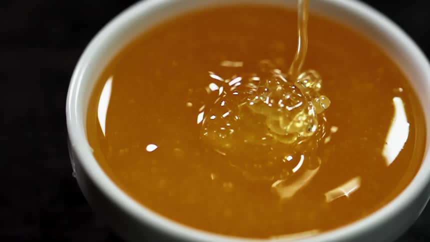 Golden sauce pours down to fill white bowl