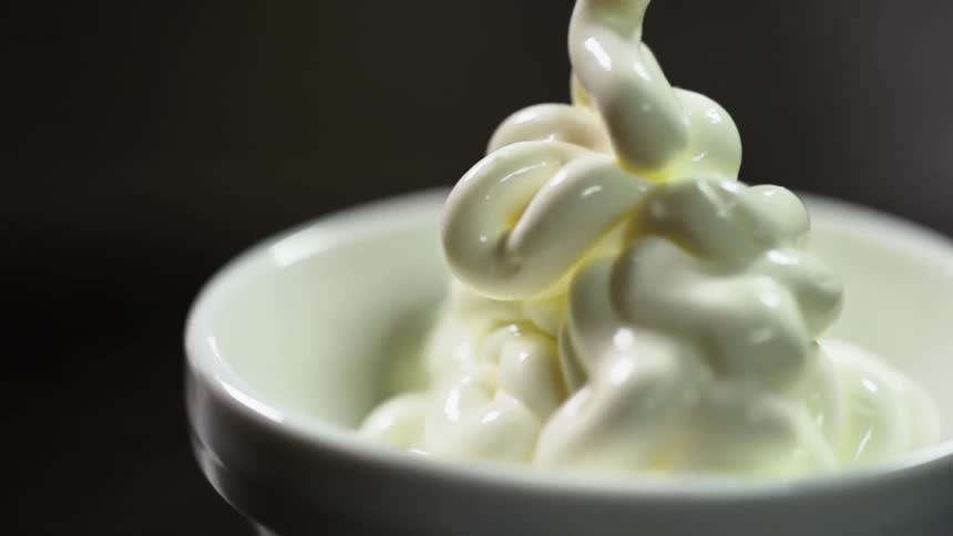 Soft serve vanilla ice cream is poured into a small white bowl