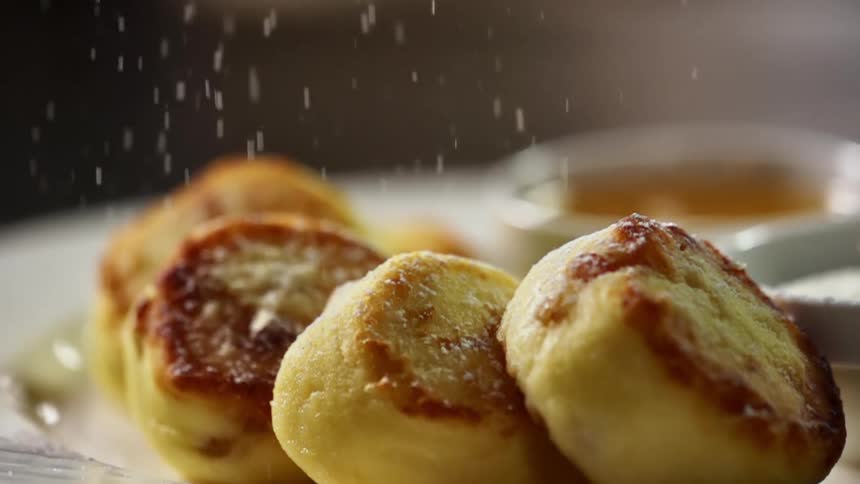 Flour sprinkles down on pieces of fried bread