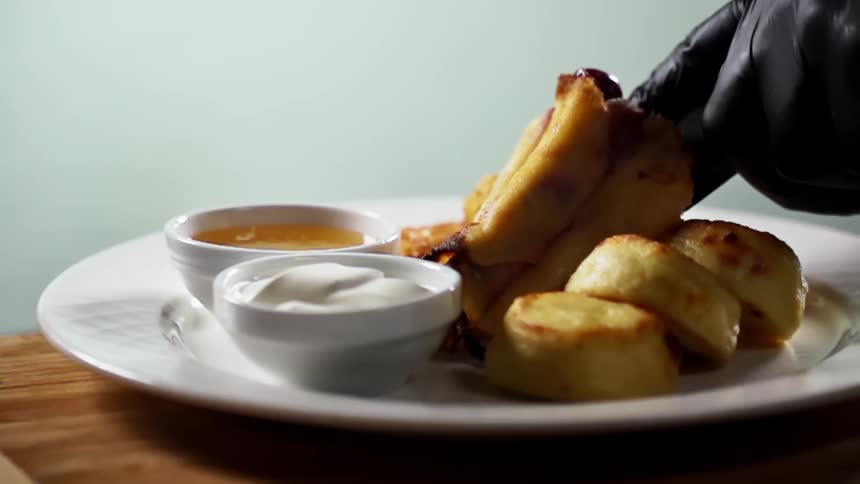 Filled crepes are placed on a plate with dipping sauces and custard