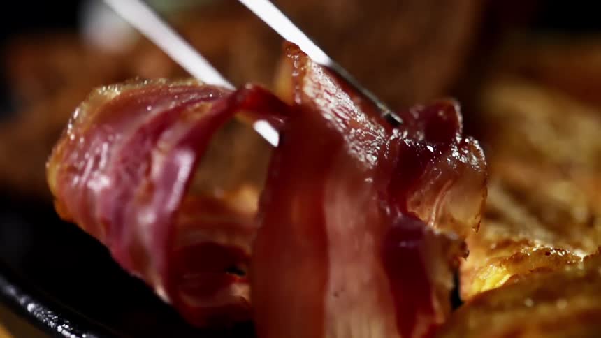 Bacon is placed on the breakfast plate