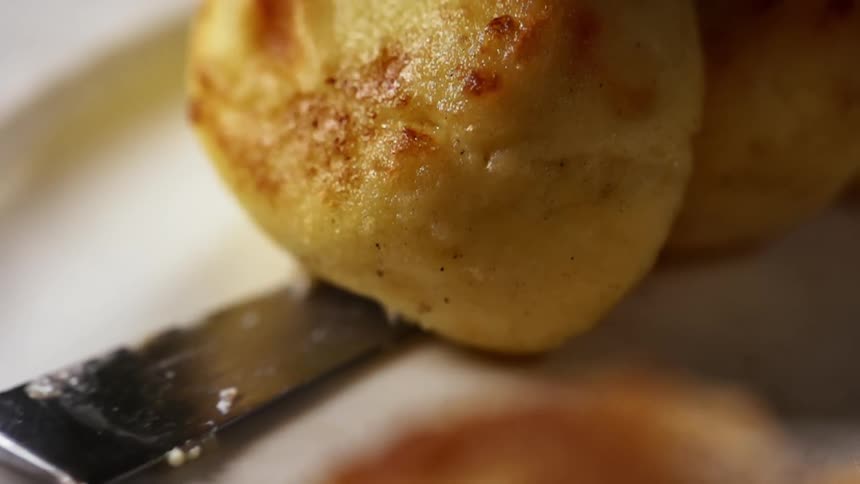 A spatula pulls out from underneath a dessert type food on a dish