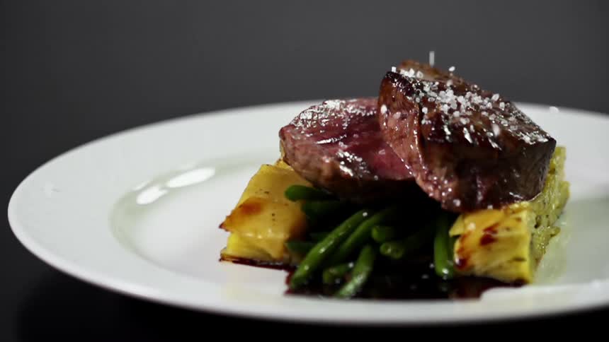 Large flakes of sea salt are added to a steak and potato dish