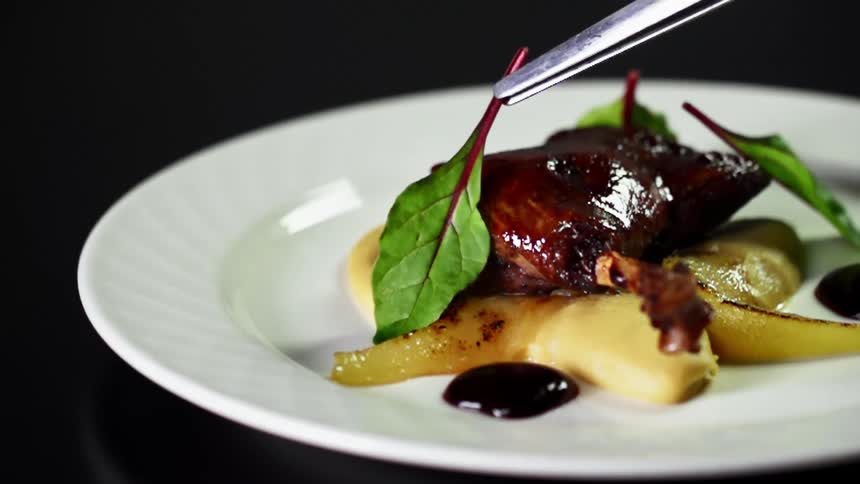 A garnish is being put on a meal