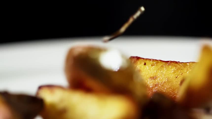 Potato wedges are dropped on the plate