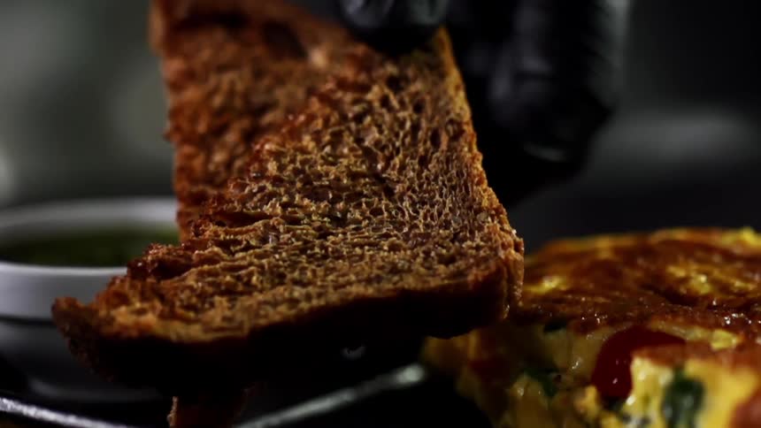 A piece of toast is placed next to the omelette