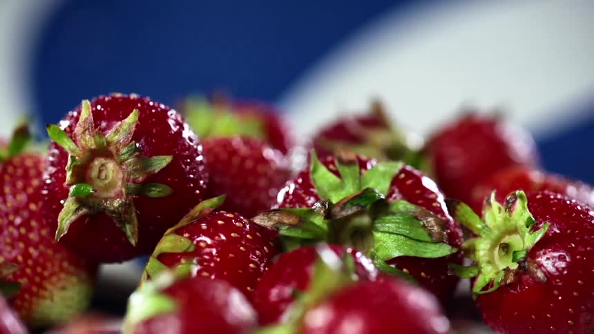 Strawberries falling on top of other strawberries