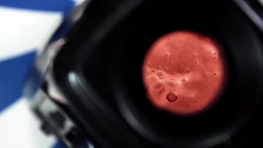 Red juice spins inside a blender