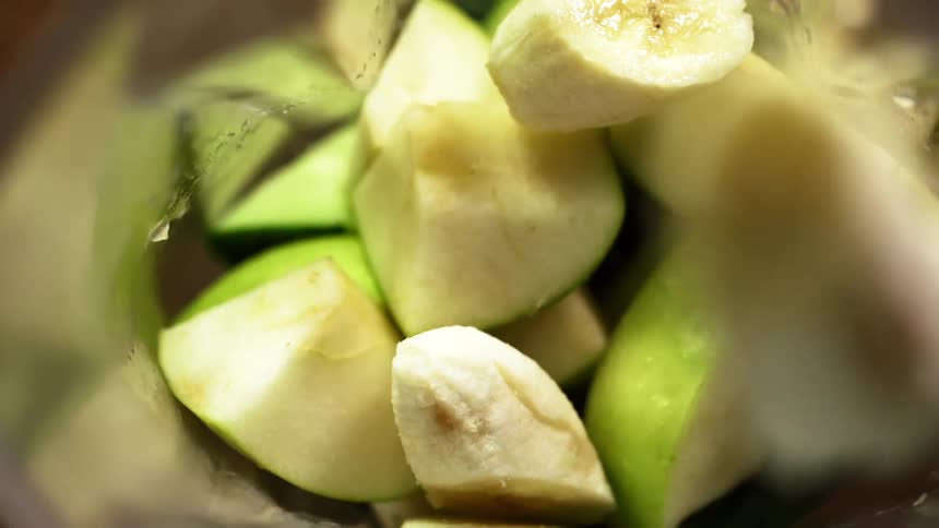 Pieces of banana and apple are dropped in a blender