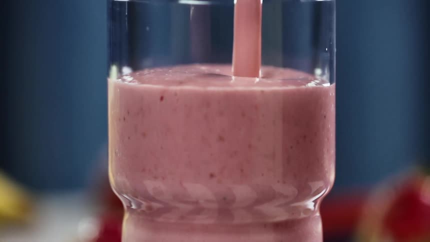 A fruit smoothie being poured in to a glass