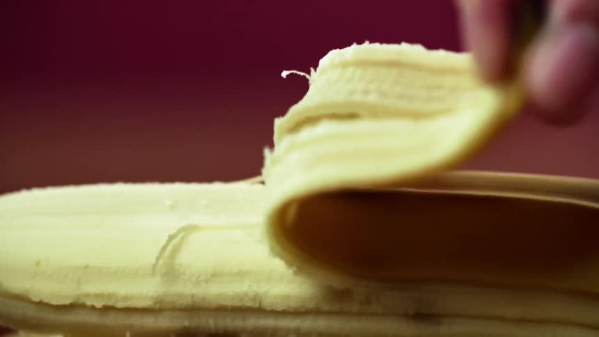 A white man peels a banana