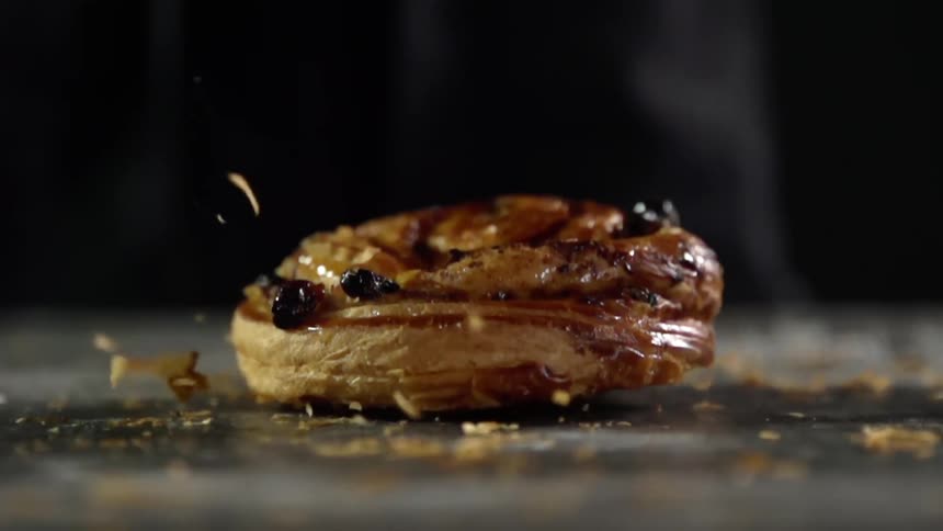 A cinnamon raisin bun falls on the ground