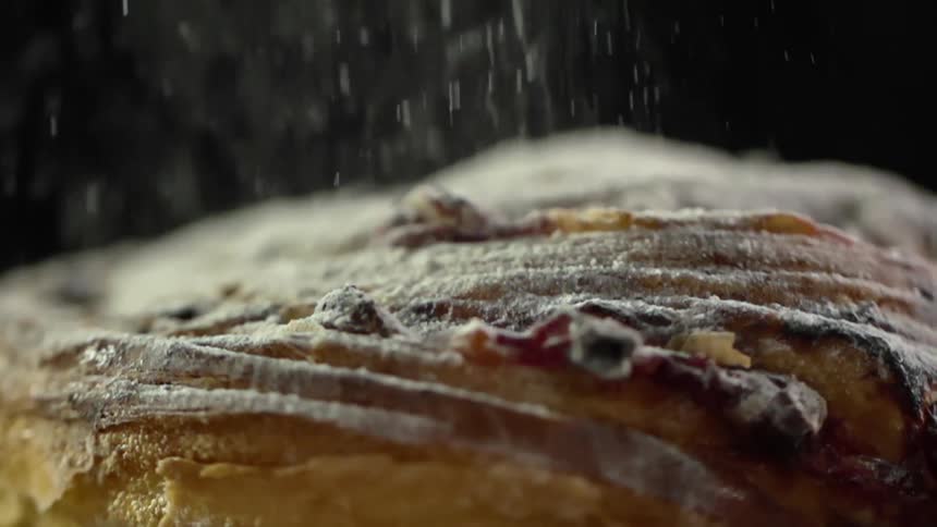 A puffed pastry treat is topped with powdered sugar