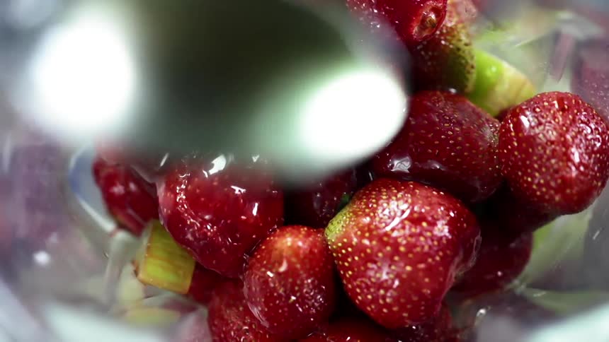 Glaze is spooned over a bowl of strawberries
