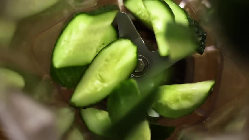 Chunks of cucumber dropping into a blender