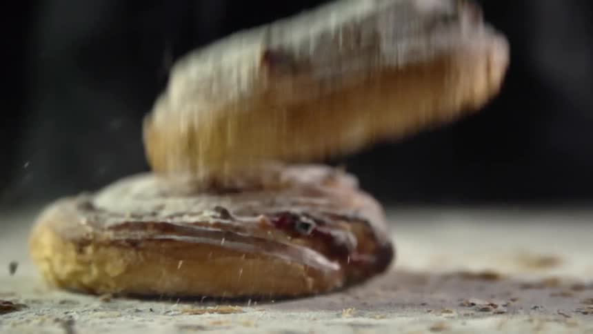 Sweet pastries covered in confectioners sugar fall bouncing over a table