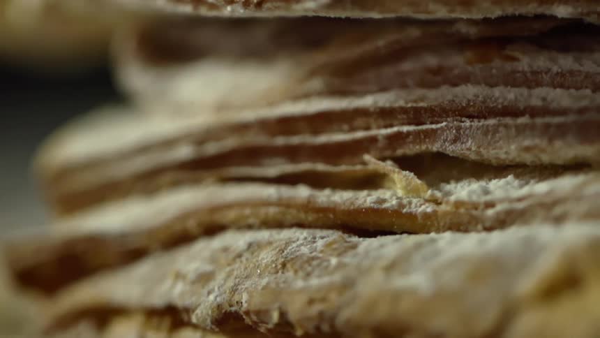 A bread is stacked and covered with flour