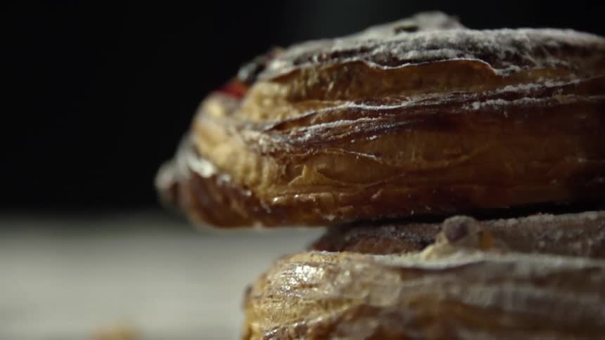 Croissants covered in confectioners sugar plied up onto each other