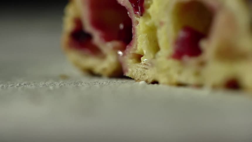 A pastry is cut in half to show the jelly inside